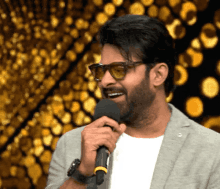 a man wearing sunglasses holds a microphone in his hand
