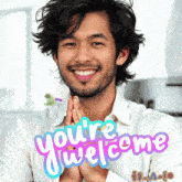 a man with his hands folded and the words you 're welcome behind him