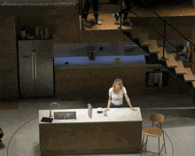 a woman is standing at a kitchen counter with a book on it
