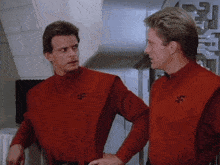 two men are standing next to each other wearing red uniforms with the letter f on them