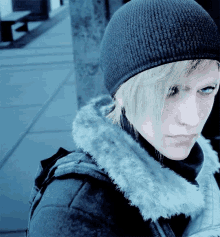 a woman wearing a beanie and a fur collar looks at the camera