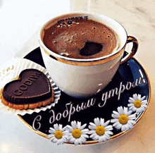a cup of coffee sits on a saucer with flowers and a cookie that says godiva on it