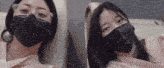 a woman wearing glasses and a black mask sits next to another woman wearing a black mask