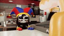 a cartoon character wearing a jester hat is sitting at a counter in a restaurant