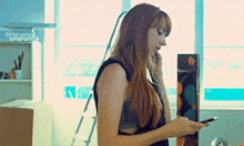 a woman is talking on a cell phone while looking at her phone
