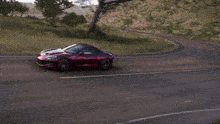 a red sports car is driving down a road
