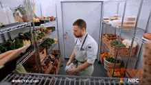 a man in an apron is standing in front of a nbc logo