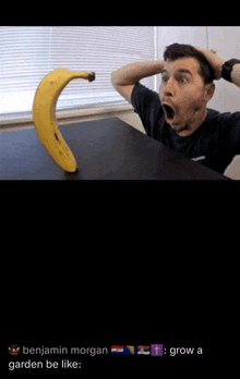 a man is sitting at a table with his mouth open and a banana in the background