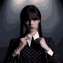 a woman in a black dress with white collar and braids