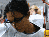a close up of a woman wearing glasses and a white coat