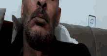 a man with a beard and mustache is sitting on a couch .