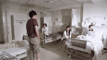a man in a brown shirt is standing in a hospital room with a sign on the wall that says ' ambulance '
