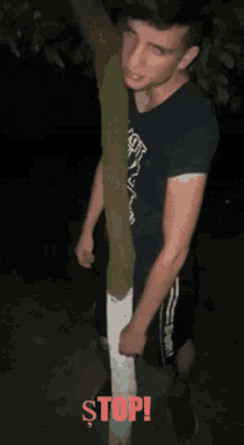 a man wearing a t-shirt that says " i 'm not my best you " is standing next to a tree