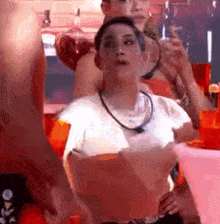 a woman is sitting at a table with her hands on her hips and looking at something .
