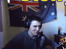 a man wearing headphones and a microphone is smiling in front of an australian flag