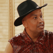 a man wearing a black hat and a red shirt