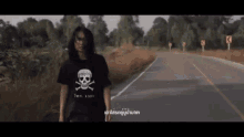 a man in a black shirt with a skull and crossbones on it