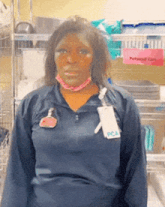 a woman wearing a blue pca shirt stands in front of a pink sign that says personal care