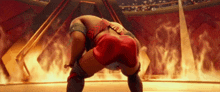 a cartoon of a wrestler in a ring with flames behind him