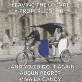 a man is riding a bicycle with a blue and white rickshaw pulled by two people