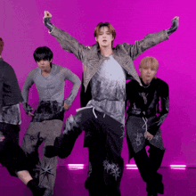 a group of young men are dancing in front of a pink background