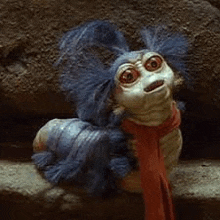 a labyrinth worm with blue hair and a scarf around its neck .