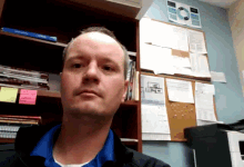 a man taking a selfie in front of a bulletin board that says " i 'm sorry " on it