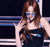 a woman with red hair wearing sunglasses and a microphone in her mouth