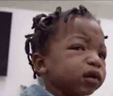 a baby is crying and making a funny face .