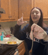 a woman in a navy sweatshirt is holding a fork in her hand