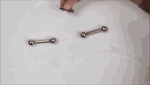 a man 's hand is holding a metal object that looks like a letter l