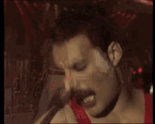 a man with a mustache singing into a microphone