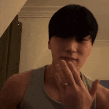 a man wearing a ring on his finger is covering his mouth