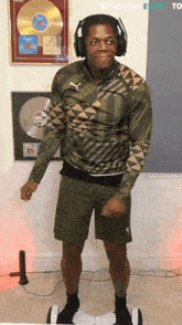 a man wearing headphones is standing on a hoverboard