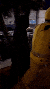 a man in a yellow suit is walking down a bridge at night