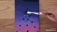 a person is brushing a painting with a toothbrush and the painting is made in animatica