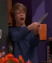 a young boy is holding a knife and a piece of bread .