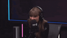 a woman wearing headphones is sitting in front of a microphone that says bbc radio 1