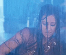 a woman is standing in the rain behind a window with her eyes closed .