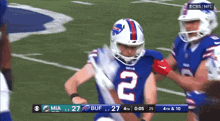 a football player with the number 2 on his jersey is being tackled by another player