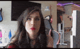a woman with red lipstick is sitting in a chair in front of a tv