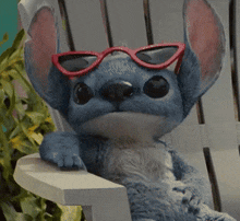 a stuffed animal wearing red sunglasses sitting on a chair