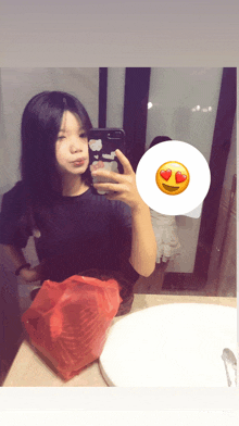 a girl taking a picture of herself in a mirror with a smiley face in the corner