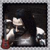 a picture of a man holding a guitar with the caption johnny loves toby