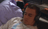 a man wearing headphones is laying on a bed with his eyes closed