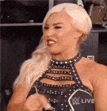 a woman in a black dress is smiling and making a face .