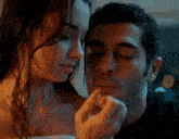 a man and a woman are looking at each other with their eyes closed