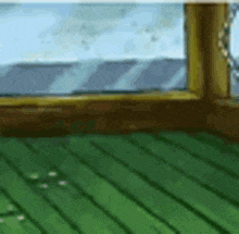 a room with a green floor and a window with a view of the ocean .