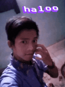 a young man taking a selfie with the words haloo written above him