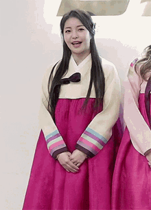 a woman in a pink dress is standing next to a woman in a pink dress